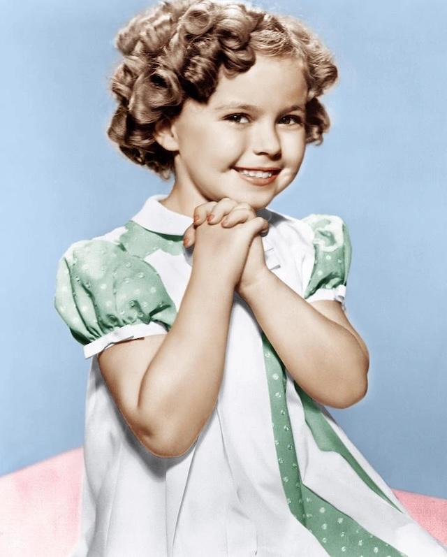  This image shows a young Shirley Temple, the curly-haired child star whose smile lit up the silver screen in the 1930s